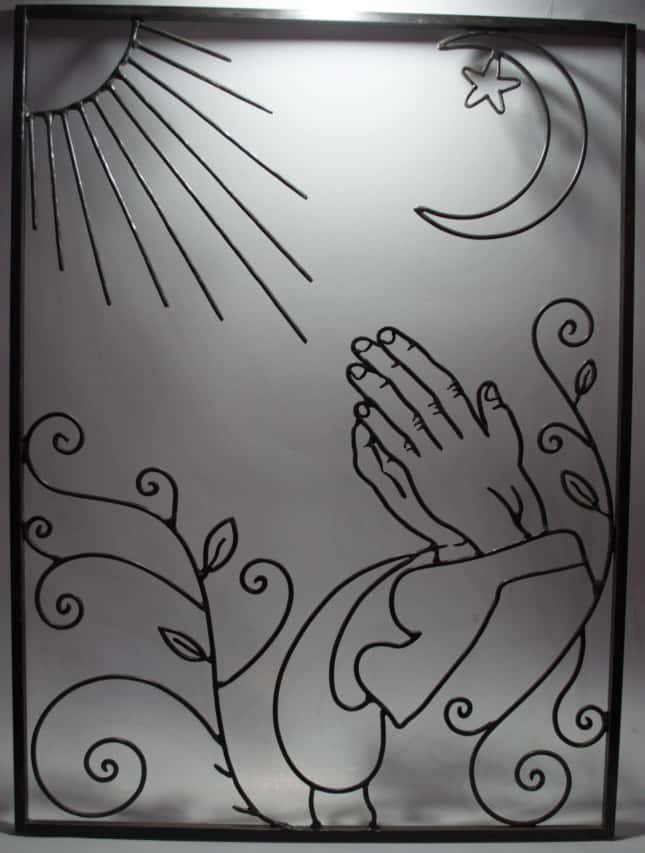 Decorative wrought iron panel featuring praying hands, sun, moon, and floral scrolls by LaksourCrafts in Marrakech